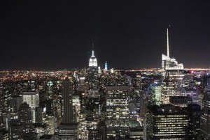 Das Empire State Building und der Fiancial district im Hintergrund bei Nacht.